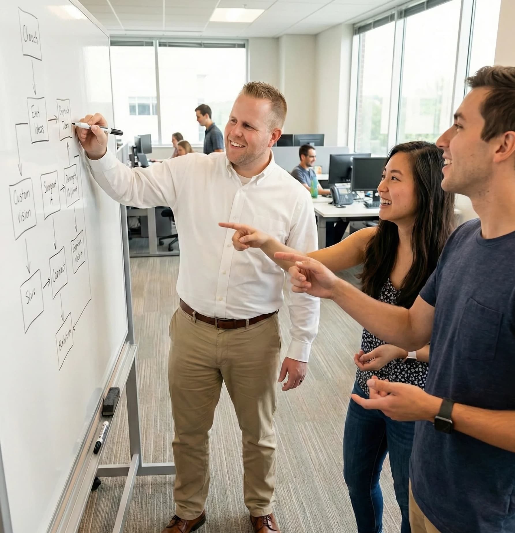 Colin at whiteboard designing systems with team members